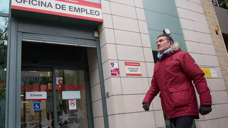 Una persona camina frente a la entrada de una oficina de empleo en Madrid, a 4 de diciembre de 2023