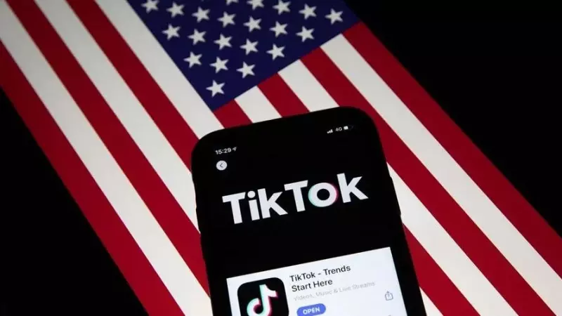 Un móvil con la aplicación China TikTok, sobre una bandera de EEUU.
