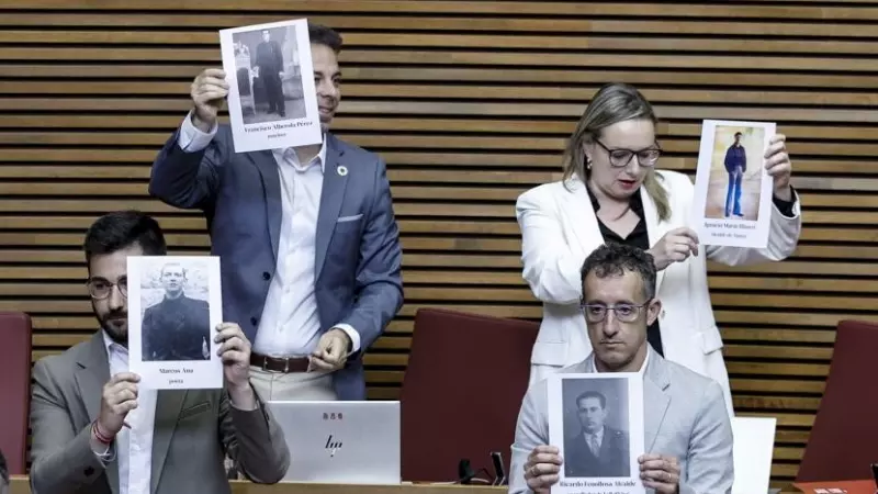 Los diputados socialistas muestran fotos de represaliados por la dictadura antes del comienzo del pleno de Les Corts Valencianes.