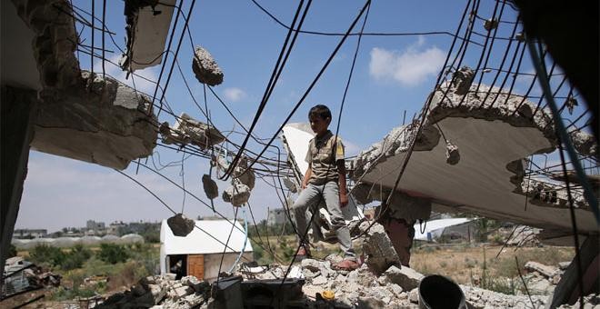Un niño palestino juega en los escombros de las casas destruidas durante la guerra de 50 días entre Israel y Hamas militantes. AFP./ SAID KHATIB