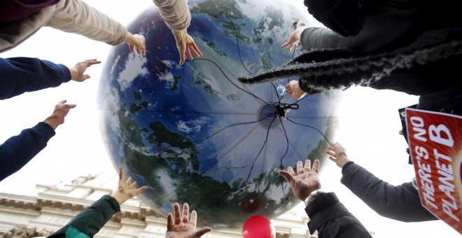 Manifestantes tiran un globo enorme con forma de mundo en la protesta de Roma, Italia, por el cambio climático. REUTERS/Alessandro Bianchi
