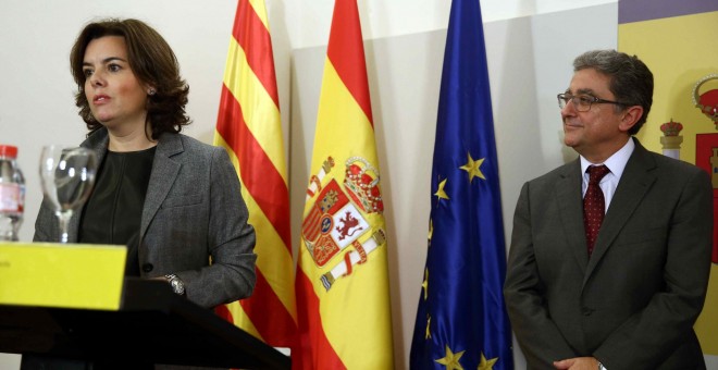 El nuevo delegado del Gobierno en Cataluña, Enric Millo, escucha la intervención de la vicepresidenta del Gobierno, Soraya Sáenz de Santamaría, tras jurar su cargo en un acto celebrado en Barcelona. EFE/Toni Albir