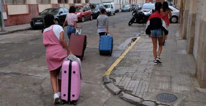 Varias de las menores marroquíes devueltas de Palencia a Melilla cargan con sus maletas en la ciudad autónoma.- JOSÉ PALAZÓN/PRODEIN
