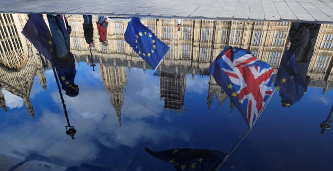 Banderas del Reino Unido y de la UE, reflejadas en un charco de agua frente al Parlamento británico, en Westminster, en una manifestación conraria al brexit. REUTERS/Toby Melville