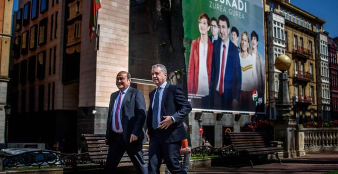 El lehendakari Iñigo Urkullu y el presidente del PNV, Andoni Ortuzar, caminan delante del cartel electoral de su formación. | EFE