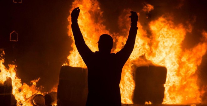 Un joven antisistema celebra el incendio de una barricada en el centro de Barcelona. GUILLEM SANS