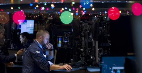 Un operador de la bolsa de Wall Street, rodeado de la decoración navideña en el parqué. REUTERS/Carlo Allegri