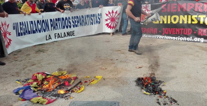 Un grupo de ultraderechistas quema esteladas en Barcelona durante la celebración del 12 de octubre, en 2015.- EFE