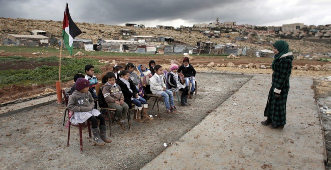 Una maestra palestina durante una clase a niños en la comunidad de Abu Nawar cerca del asentamiento judío de Maale Adumim, en la ciudad cisjordana de Al-Azariya, al este de Jerusalén. AHMAD GHARABLI / AFP