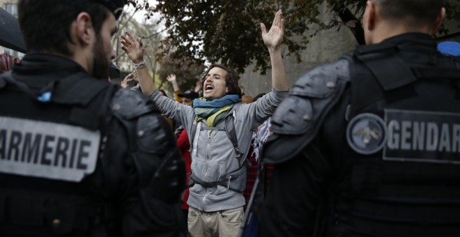 Gendarmes franceses frente a los manifestantes del movimiento Nuit Debout en una concentración frente al Museo del Hombre de Par´si, contra la reforma laboral impulsada por el Gobierno de Hollande. AFP/ KENZO TRIBOUILLARD