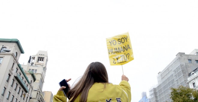 Una joven subida a los hombros de una persona con pancarta en la que se lee 'Yo soy humana, ¿y tu?' - Arancha Ríos