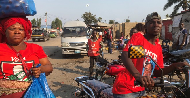 Varias personas vestidas con camisetas del partido gobernante, el Frelimo, en un mercado en Beira, Mozambique.- REUTERS / Emma Rumney