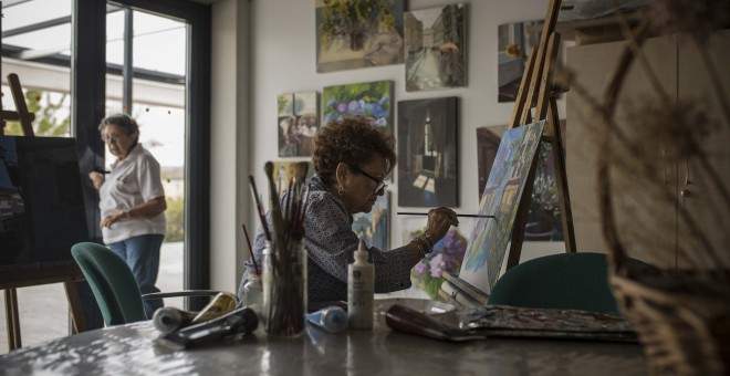 Marisa Hidalgo, de 76 años, pinta un cuadro en la sala de pintura y escultura de Trabensol. Aunque tenía un comercio, su pasión era pintar, y ahora imparte talleres a los demás residentes del complejo.- JAIRO VARGAS