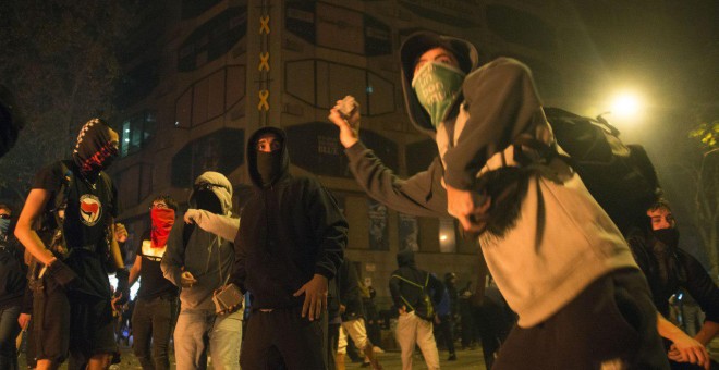 Jóvenes encapuchados lanzan piedras contra la Policía en Barcelona. GUILLEM SANS