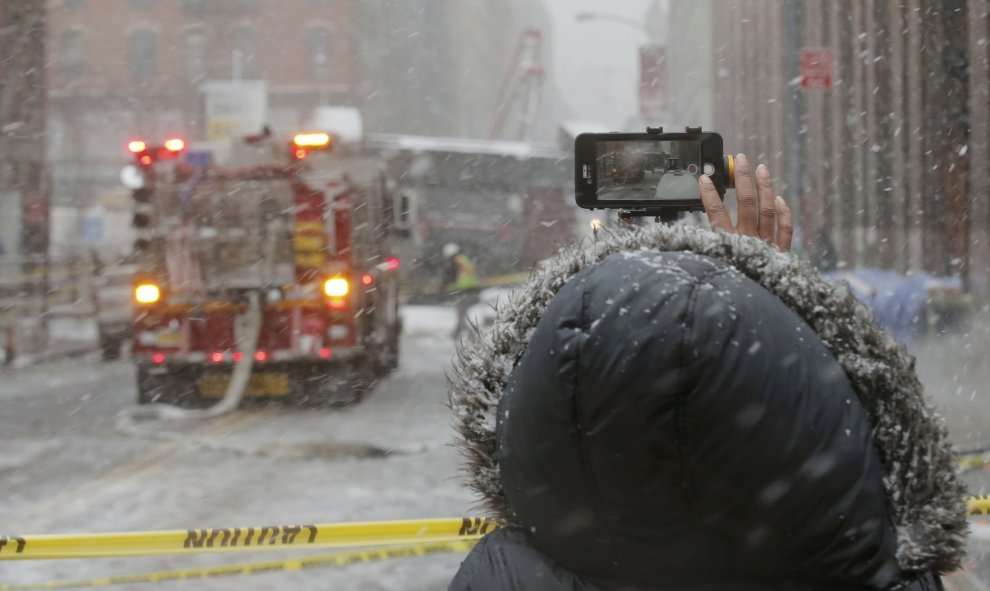 Mujer fotografía una calle tras la caída de una grúa en el centro de Manhattan. REUTERS/Brendan McDermid