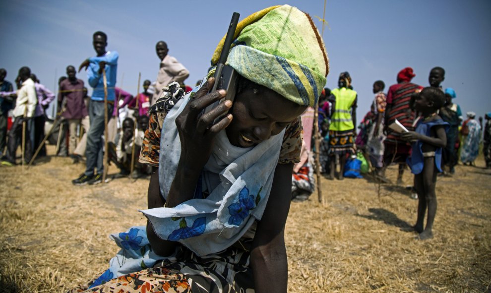 Una mujer de Sudán del Sur, utiliza un teléfono por satélite proporcionado por el Comité Internacional de la Cruz Roja para llamar a sus familiares perdidos, que huyeron del pueblo tras los enfrentamientos entre las fuerzas del Ejército y la el movimiento