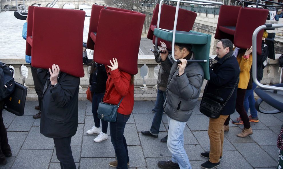Manifestantes llevan las sillas robadas de las oficinas bancarias para protestar contra el fraude fiscal, en París. REUTERS/Charles Platiau