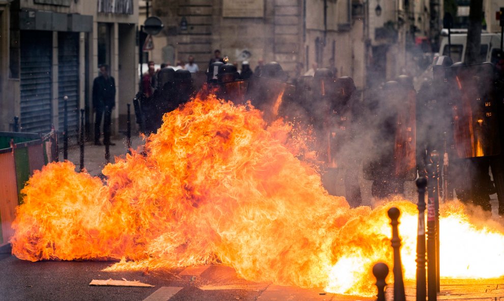 Un cóctel mólotov explota al lado de varios policías durante una manifestación contra la nueva reforma laboral en París.- EFE/Etienne Laurent