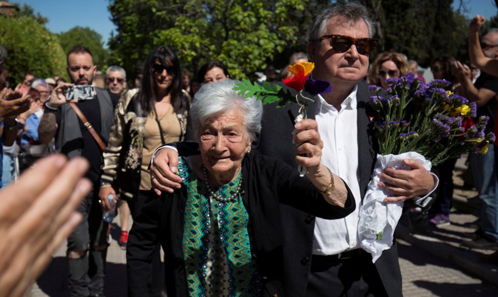 La lucha de una vida. Ascensión levanta unas flores con los colores republicanos junto a su hijo.- REUTERS