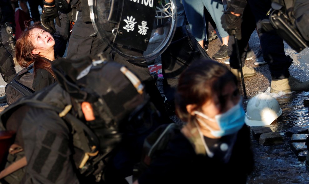 La policía antidisturbios detiene a manifestantes antigubernamentales.- REUTERS / Tyrone Siu