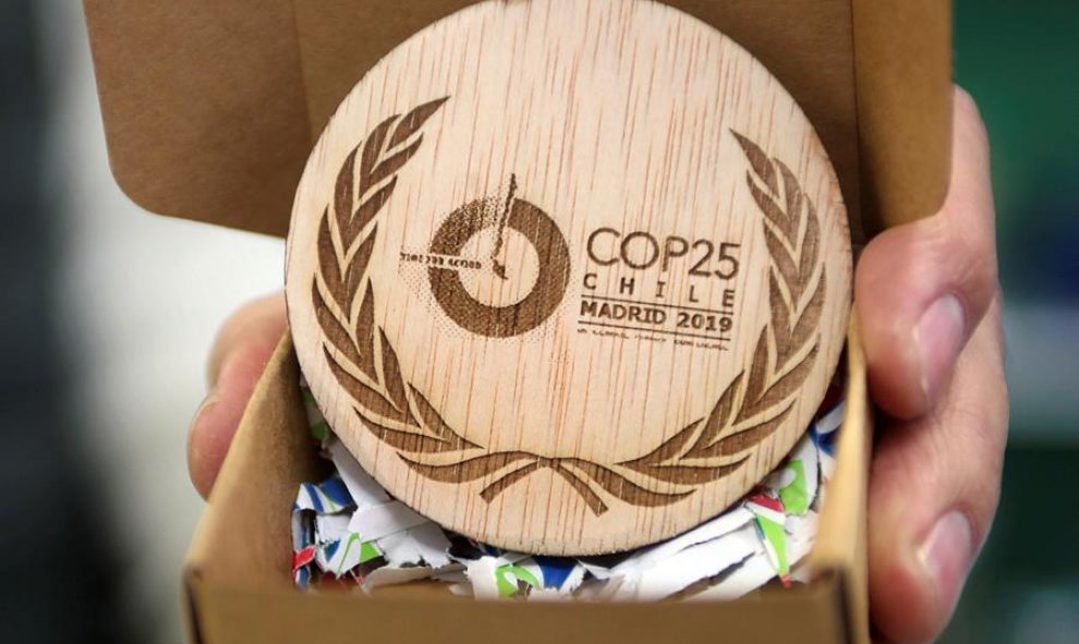 Detalle de las medallas conmemorativas de la Cumbre del Clima, un disco de madera grabado con los logotipos de la COP25 y de Naciones Unidas, diseñadas y fabricadas por una empresa domiciliada en Soria (Trofeos Romero) a partir de madera excedente de los
