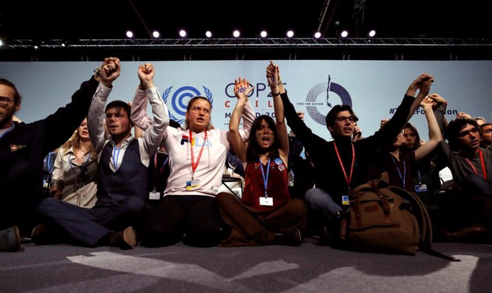 Varios activistas alzan sus manos después de la sesión plenaria de la Cumbre Climática, en el segundo día de negociaciones de alto nivel para tomar medidas adicionales contra la emergencia climática este miércoles en Ifema en Madrid. EFE/ J.J. Guillén