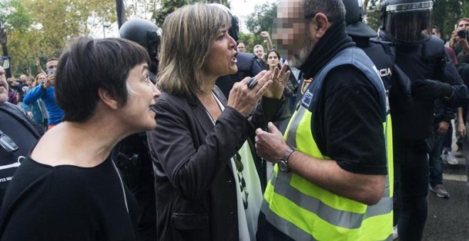 La alcaldesa de L'Hospitalet de Llobregat, Nuria Marin, se enfrenta a un policía fuera de la Escuela Can Vilumara. EFE/Quique García