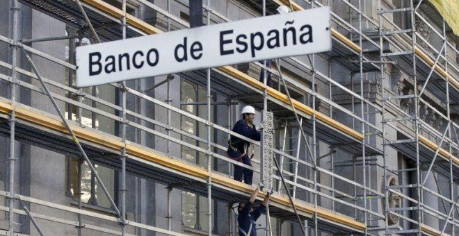 Unos trabajadores montan un andamio en la fachada del edificio del Banco de España, en Madrid. REUTERS