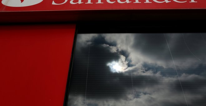 Las nubes se reflejan en la ventana de una sucursal del Banco Santander en Sevilla. REUTERS/Marcelo del Pozo