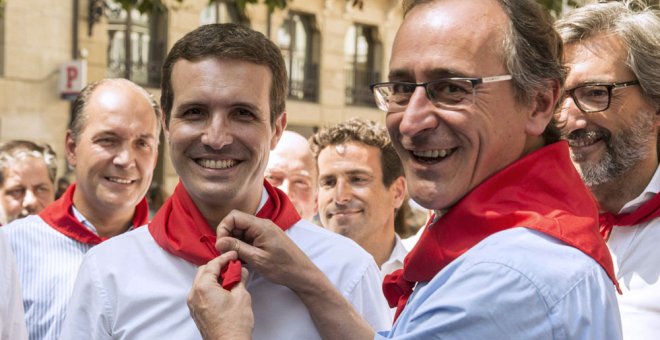 El presidente del PP del País Vasco, Alfonso Alonso, pone al presidente de los populares, Pablo Casado, el pañuelo festivo durante la visita de ésta a Vitoria. EFE