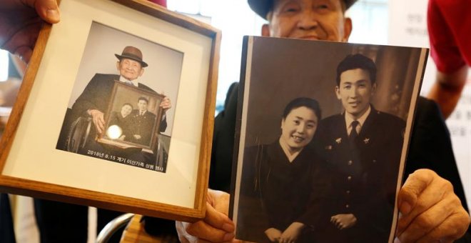 Un surcoreano enseña una de las fotos que dará a su familia en una de las reuniones organizada entre las dos Coreas - EFE