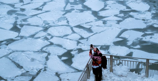 Una mujer fotografía el río de Chicago congelado por las bajas temperaturas que afectan al medio oeste de Estados Unidos. / REUTERS-Pinar Istek