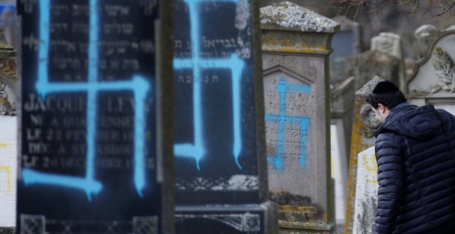 Un hombre camina entre las tumbas que fueron profanadas con esvásticas en el cementerio judío de Quatzenheim. / Reuters