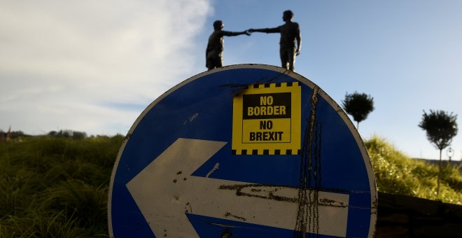 Una pegatina de 'No fronteras, no brexit', en una señal de tráfico frente a la estatua de la Paz titulada 'Hands Across the Divide' en Londonderry, Irlanda del Norte. REUTERS / Clodagh Kilcoyne