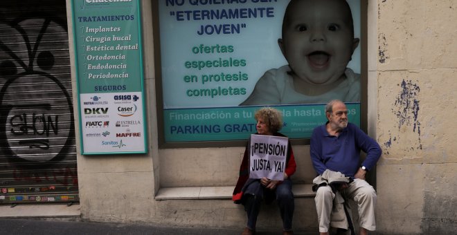 Un hombre y una mujer descansan tras participar en una manifestación reclamando pensiones justas. REUTERS/Susana Vera