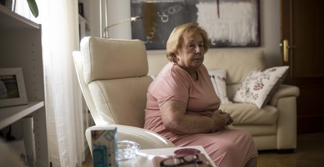 María del Carmen García, en el salón de su casa, en la calle Toledo de Madrid. Casi tres décadas después de comprar su casa, está rodeada de turistas e inquilinos que se marchan.- JAIRO VARGAS