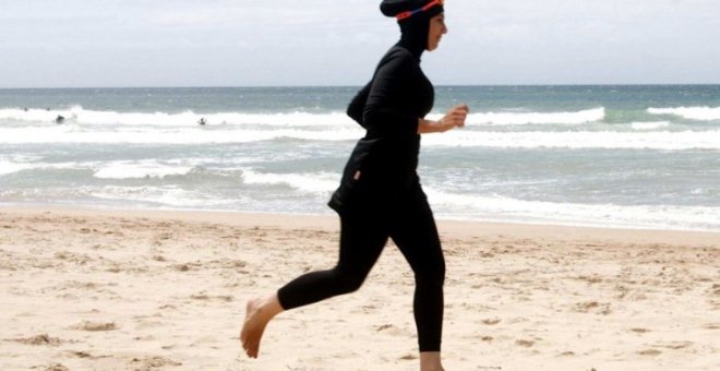 Una mujer con 'burkini', en la playa.- REUTERS