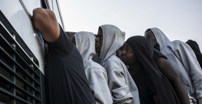 Varios migrantes suben a un autobús de la Guardia Civil para ser trasladados desde el puerto de Algeciras, en agosto de 2018.- JAIRO VARGAS (ARCHIVO)