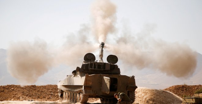 Un miembro de Hezbolá reacciona mientras dispara un arma en el oeste de Qalamoun, Siria. REUTERS / Omar Sanadiki