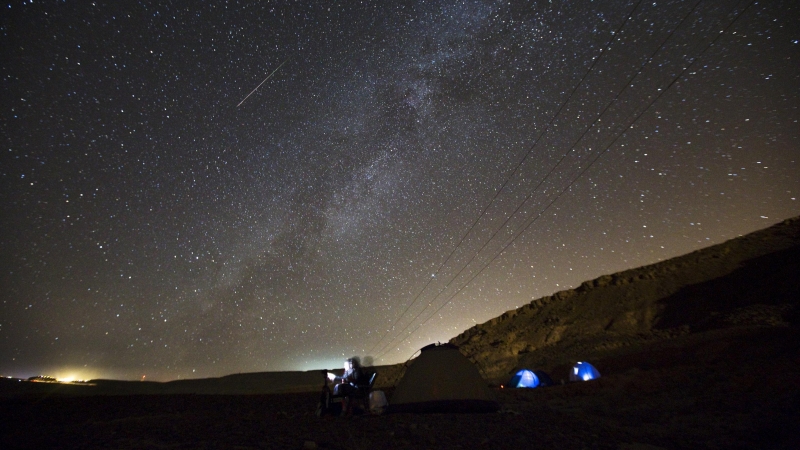 Los meteoros cruzan en el cielo mientras un hombre los observa durante la lluvia de estrellas cerca del pueblo de Mitzpe Ramon, al sur de Israel.- REUTERS / Amir Cohen