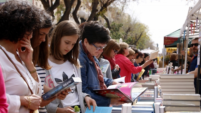 Diverses lectores fullejant llibres a la Rambla Nova de Tarragona amb motiu de Sant Jordi. ROGER SEGURA / ACN