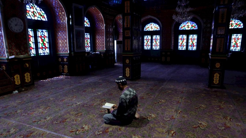 Un musulmán lee el Corán en el interior de una desierta mezquita durante el Ramadán en la ciudad de Srinagar (India). /EFE
