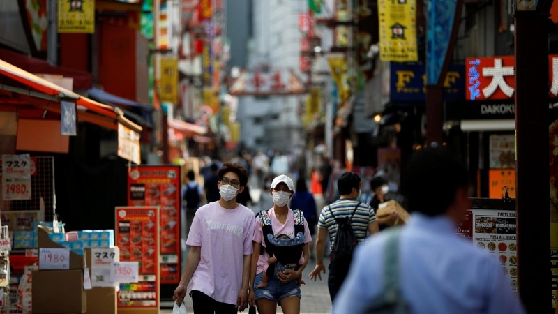 Transeúntes con máscarillas por una calle  de Tokio. REUTERS / Issei Kato