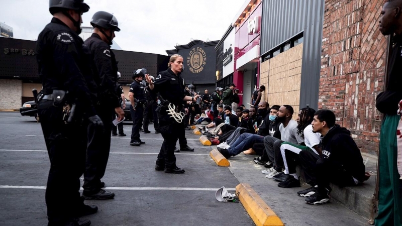 Los manifestantes son arrestados por agentes de policía después del toque de queda durante las protestas por la muerte de George Floyd, en Hollywood. EFE / ETIENNE LAURENT