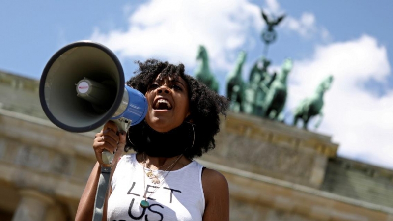 Una mujer sostiene un megáfono durante una protesta contra la muerte de George Floyd, en la Puerta de Brandenburgo en Berlín, Alemania. REUTERS / Christian Mang