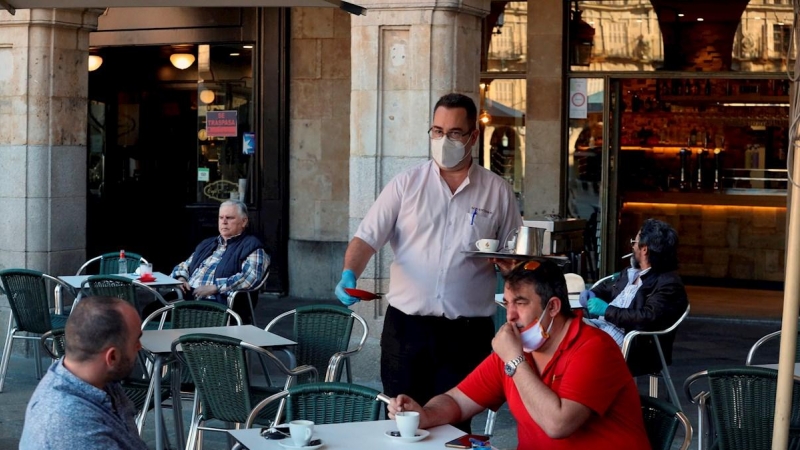 Un camarero sirve a los clientes en su bar de la Plaza Mayor de Salamanca. EFE/JM García