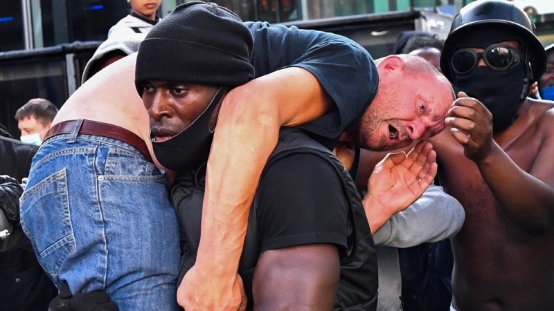 Un hombre que protestaba en Londres por la muerte de George Floyd sostiene a otro que participaba en una marcha contraria al Black Lives Matter.  REUTERS/Dylan Martinez