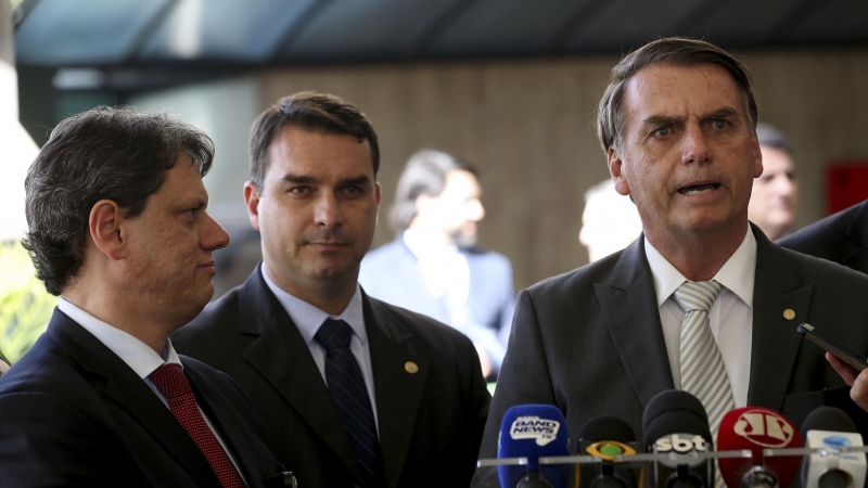 El presidente Jair Bolsonaro y su hijo mayor, el senador Flávio Bolsonaro, junto al ministro de infraestructuras, capitán Tarcísio Gomes de Freitas. WILSON DIAS/ AGÊNCIA BRASIL.