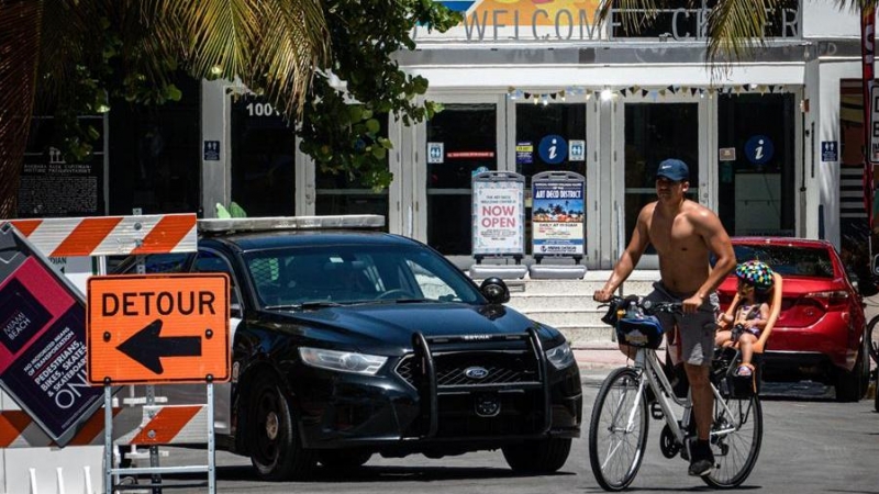 Un hombre y un niño fueron registrados este viernes al recorrer, en bicicleta y sin protección facial, el paseo turístico de Ocean Drive, en Miami Beach (Florida, EE.UU.). EFE/Giorgio Viera