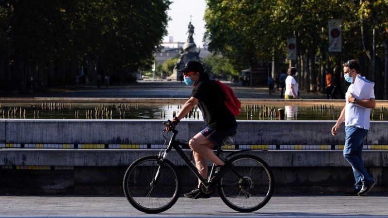 Un hombre circula en bicicleta y con mascarilla por el centro de la ciudad de Valladolid. EFE/ Nacho Gallego